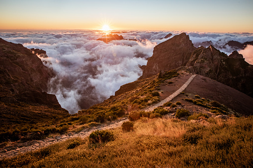 Beautiful mountains landscape with clouds under peaks and sunset light