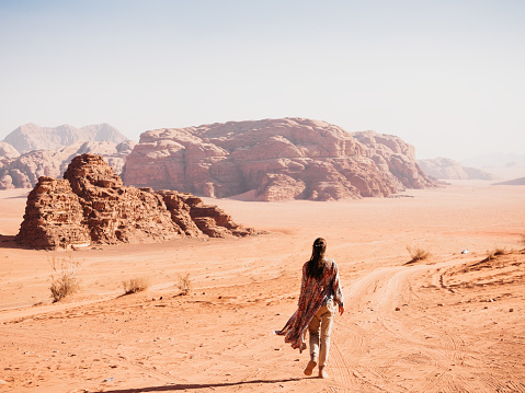 Stylish woman and the sights of the Wadi Rum desert in Jordan. Clear, sunny day. Vacation and travel concept