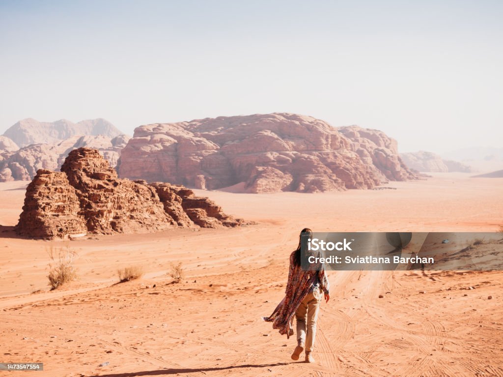 Stylish woman and the sights of the Wadi Rum Stylish woman and the sights of the Wadi Rum desert in Jordan. Clear, sunny day. Vacation and travel concept Jordan - Middle East Stock Photo