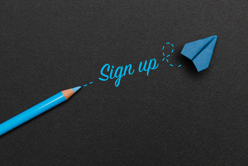 Blue pencil with Sign Up text and a blue paper plane on black background.