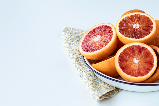 Abundance of blood orange slices on white background