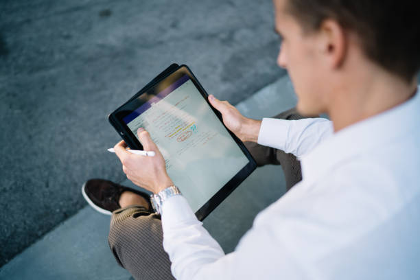istock Male employee communicating with partners in online chat using touch pad and application for editing web documents, Caucasian businessman searching financial marketing news via modern technology 1473551230