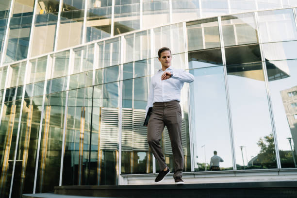 istock Caucasian businessman 30 years old checking time near office building using modern technology during work break in financial district, smart casual male entrepreneur looking at wearable equipment 1473551236
