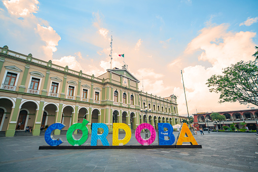 Veracruz, México - 22 de Mayo de 2021: Enormes letras de colores que dicen Córdoba en el Parque 21 de Mayo con el Palacio Municipal y un hermoso atardecer de fondo