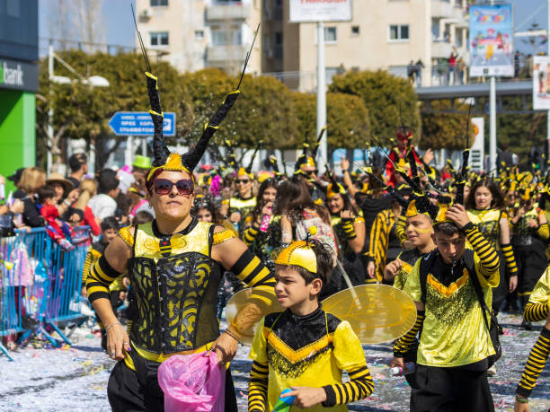 Limassol, Cyprus, February 19th, 2023:  People in bright yellow black carnival costumes taking part in Children’s Carnival Parade