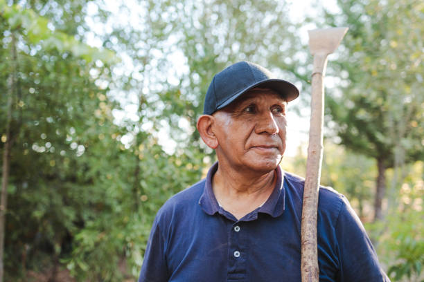 retrato en primer plano de un anciano trabajador de campo latino indígena sosteniendo un raspador de jardín. - chilean ethnicity fotografías e imágenes de stock