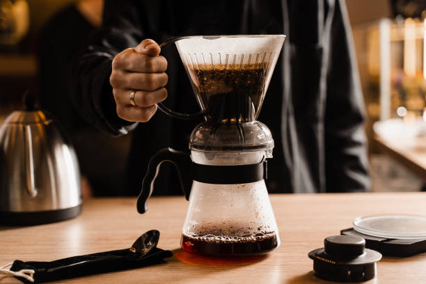 istock Pouring coffee in pot from clever dripper with pour over filter in cafe. Alternative method of brewing coffee in clever dripper at home. 1473554216