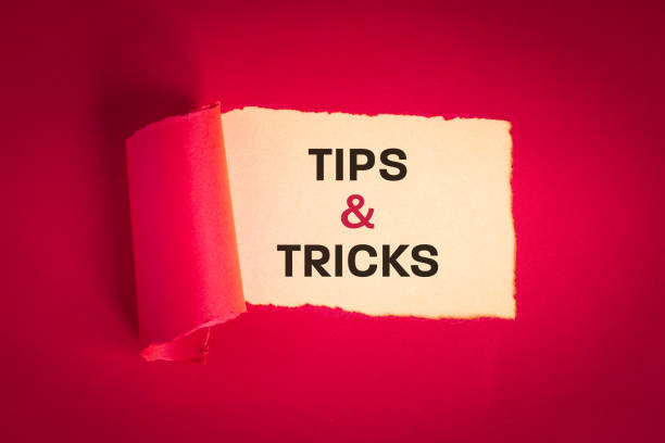istock Tips and tricks concept. text appearing behind torn paper in viva magenta, tips and tricks to help you in business, professional advice 1473555158