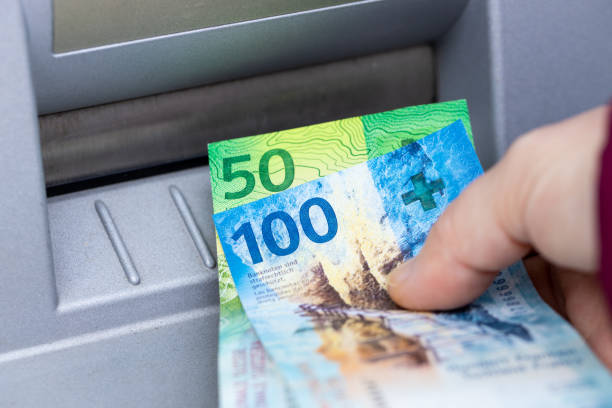a mulher está segurando dinheiro suíço retirado de um caixa eletrônico, notas de papel de 100 e 50 francos - swiss currency - fotografias e filmes do acervo