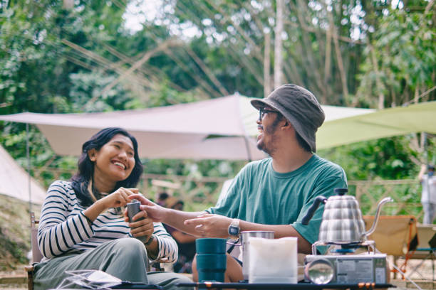 キャンプ場で一緒に朝食を作る幸せなアジアのカップル。 - 友達付き合い ストックフォトと画像