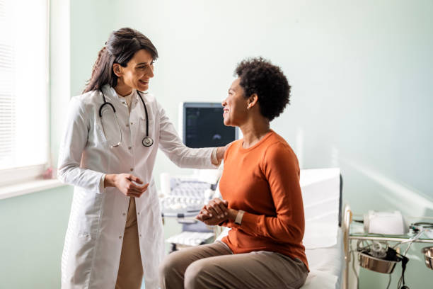 médica femenina tranquilizando a un paciente - clínica médica fotografías e imágenes de stock