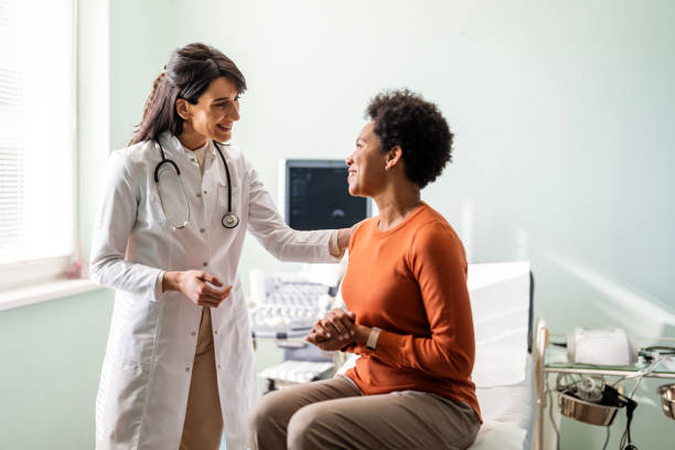 female medical practitioner reassuring a patient - doutor imagens e fotografias de stock