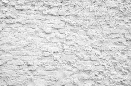 Old grunge white painted brick wall texture background. Loft-style wall