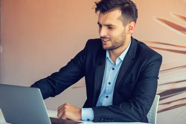 istock Handsome smiling bearded clerk man at office workplace with silver pen in arms do paperwork portrait. 1473561725