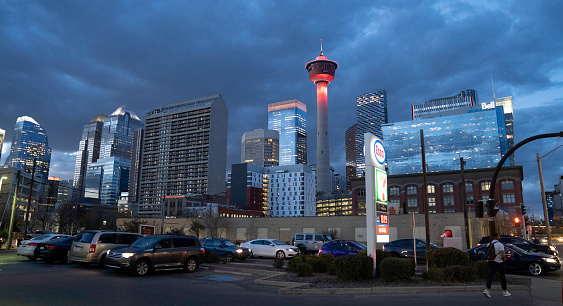 Calgary, Canada, October 1, 2021.  An urban scene in the downtown district of Calgary, in the twilight after the sun sets.  Busy people in traffic and walking.