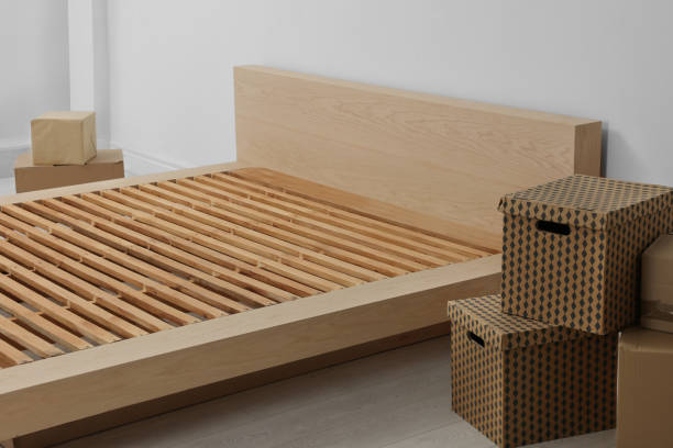 istock New wooden bed frame and moving boxes indoors 1473569242
