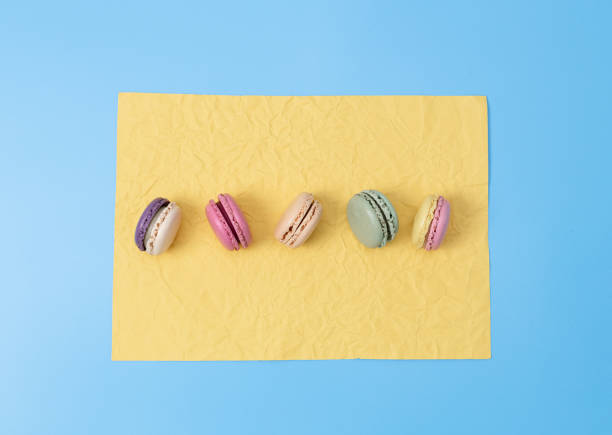 istock Five macaroons on yellow crumpled paper on a blue background. 1473572605