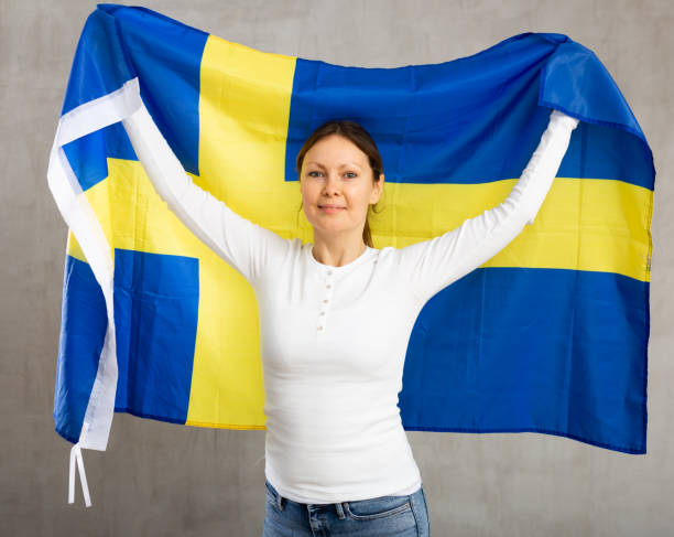 istock Happy smiling woman proudly displaying swedish flag 1473577202