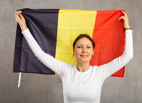 Portrait of happy woman of Belgium match waving a national flag
