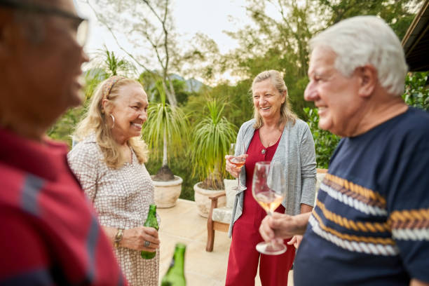 istock Senior friends with drinks enjoying weekend in backyard 1473578194