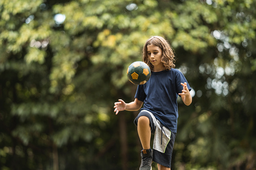 Boy practicing soccer skill outdoors
