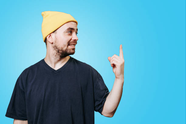 istock A smiling man with the index finger up he has an idea, eurek, studio shot on a blue background 1473584825