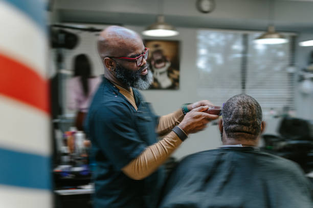 istock Rear view of customer having head shaved at barber shop 1473584875