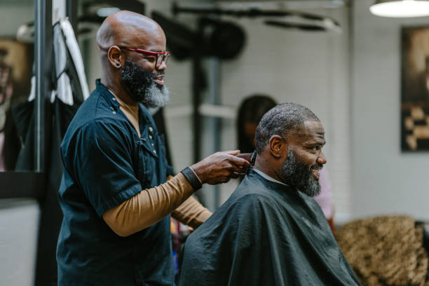istock Barber cutting hair with electric razor 1473584884