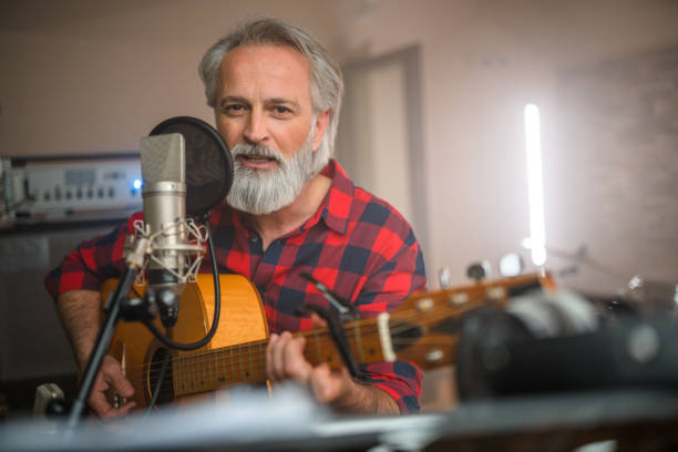 istock Senior Caucasian Guitarist Playing Classical Guitar in Recording Studio 1473586652