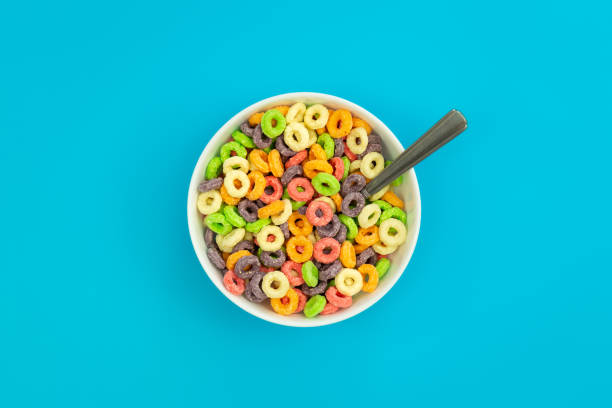 istock Colored breakfast cereals in a bowl on a blue background, top view. 1473592413