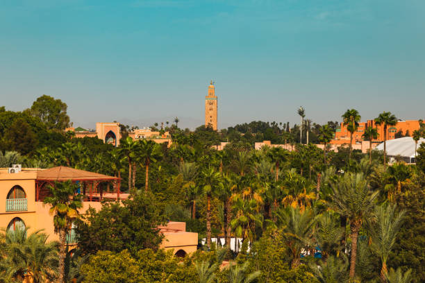 Scenic view of residential area - Marrakech, Morocco Marrakech, Morocco - 26 September 2019 : scenic view of residential area with palm trees and view of Koutoubia mosque marrakesh riad stock pictures, royalty-free photos & images