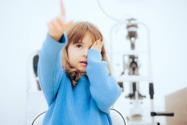 cute little girl covering one eye during ophthalmological consult - patient happiness cheerful optometrist imagens e fotografias de stock