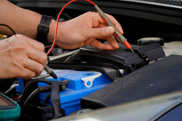 istock technician checks the battery using a voltmeter capacity tester,auto mechanic uses a multimeter voltmeter to check the voltage level in a car battery 1473597183