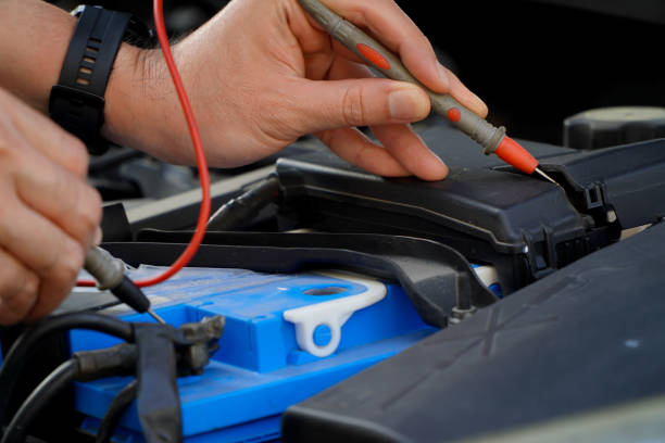 istock technician checks the battery using a voltmeter capacity tester,auto mechanic uses a multimeter voltmeter to check the voltage level in a car battery 1473597185