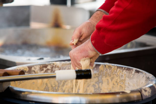 istock Close-up of a worker making beignets in an industrial kitchen. 1473599949