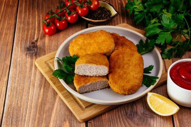 istock chicken cutlet on a plate. vegetables and herbs. wooden table 1473599983