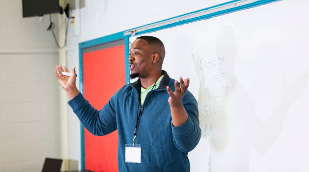 istock Male African-American math teacher at whiteboard 1473601246
