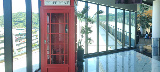 um telefone público com uma caixa de sala vermelha é instalado em uma sala pública no porto merak, banten - telephone booth telephone panoramic red - fotografias e filmes do acervo