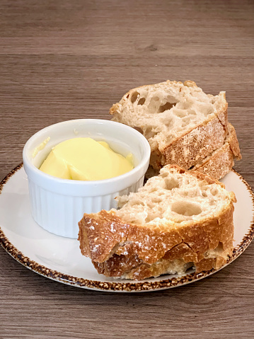 Close-up of slices of bread and butter served on saucer