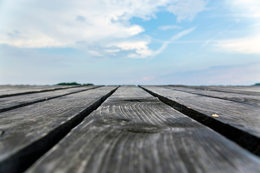 Wooden deck with sky and cloud background, soft focus, close up