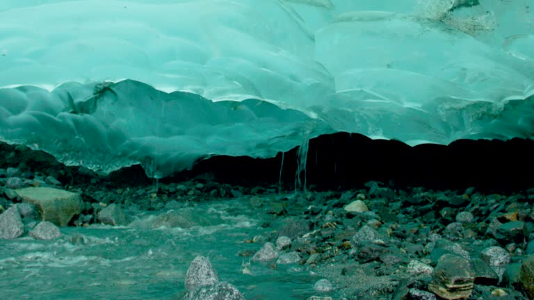 The ice under the rocks gradually melts and forms rivers. Turquoise ice.