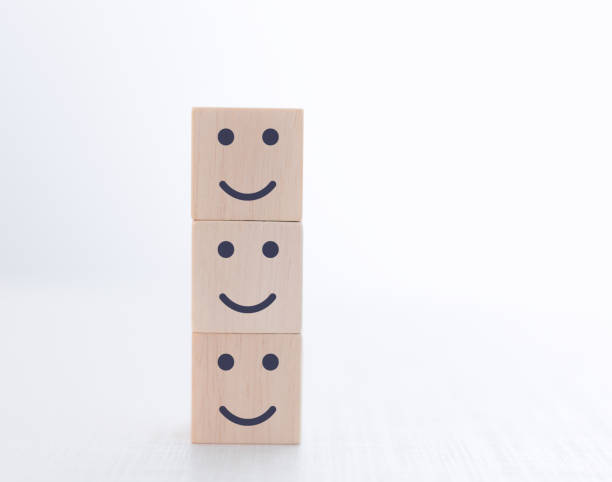 istock Satisfied face on wooden cube. Service rating. 1473615718