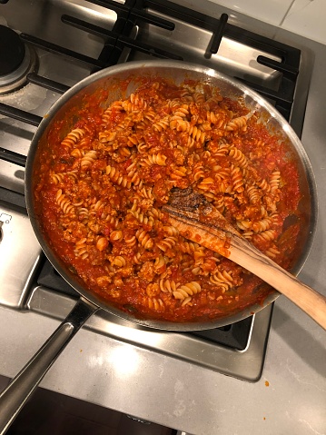 Completed fusilli with bolognese sauce ready to serve from the pan