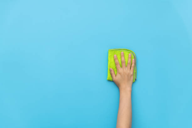 istock Woman hand cleaning blue wall with rag 1473620371