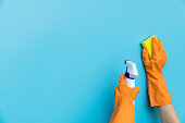 Woman hand cleaning blue wall with sponge