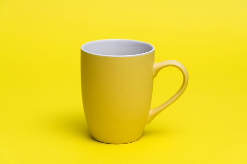 Yellow mug on yellow background.