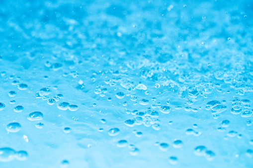 Abstract soap foam bubbles on blue flat background. Washing liquid surface