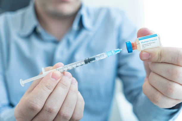 young man hand using insulin syringe close up, injecting insulin at home. self-medication - shooting up imagens e fotografias de stock