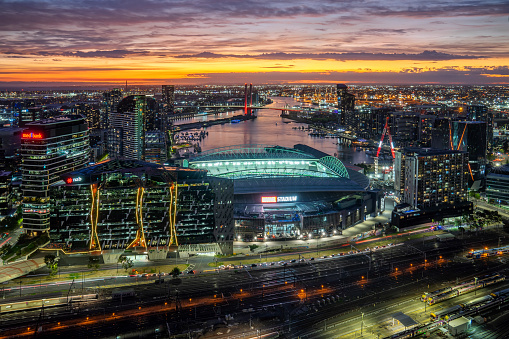 Melbourne, Australia - March 10, 2023: Office buildings, the Marvel Stadium, Bolte bridge and apartments around Victoria Harbour in the Docklands precinct at dusk.