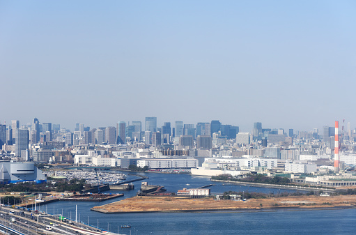 High angle view of Tokyo Bay and urban skyline against clear sky.
